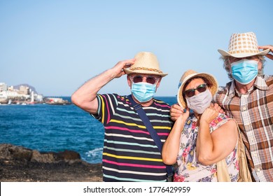 Three People Together At The Sea Wearing Medical Mask Due To Coronavirus Enjoy Freedom And Vacations - Active Retired Senior Adult