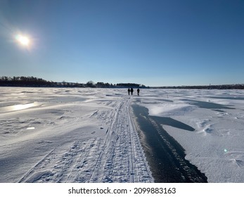 three people walking on the ice of the Volga river through the snow in winter