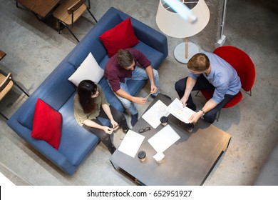 Three People Working With Documents In Cafe