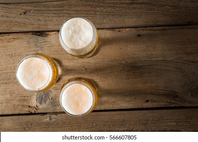 Three Pints Of Beer On A Wooden Table. Top View