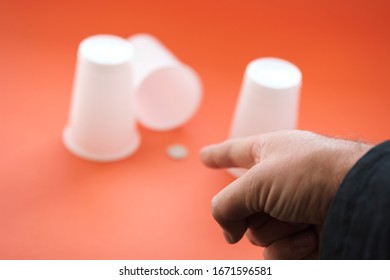 Three Plastic White Disposable Glasses Thimble Game One Of The Glass Is Open There Is A Coin. Finger Point To The Fact That The Man Guessed In Which Glass He Was Lucky