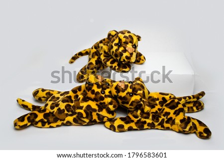 Three playing adorable looking stuffed leopard soft toys isolated on a plain white background