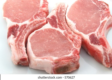 Three Plump Center Cut Pork Chops On White