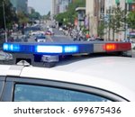 Three police cars block a boulevard in a big city. Blurred background