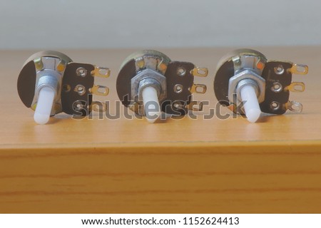 Three potentiometers on a wooden table