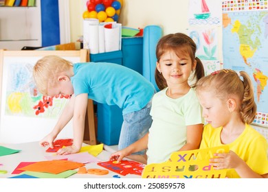 Three preschoolers in the classroom - Shutterstock ID 250859578