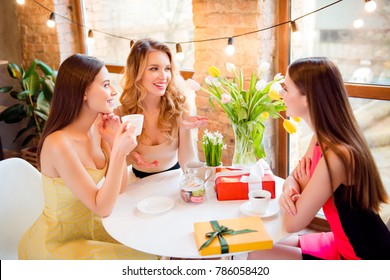 Three Pretty, Charming Girls In Elegant Dresses Sitting In Cafe, Drinking Coffee, Gossip, Talking, Spending Time Together, Enjoying, Having Snack, Brunch