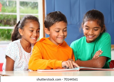 Three primary school children reading and learning together