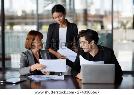 Three professionals analyzing documents in a modern office