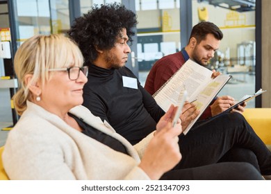 Three professionals attentively engaged in a workshop, focusing on robotics and process automation development, inspecting notes and manuals.
