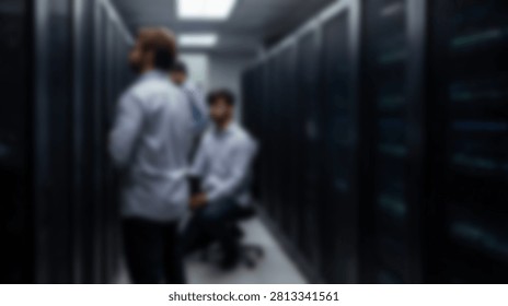 Three IT professionals in a dimly lit data center, surrounded by rows of server racks, discussing technology and infrastructure.