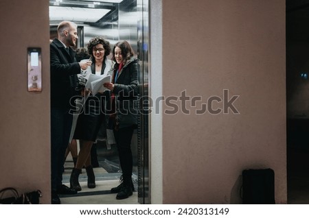 Three professionals engaged in a discussion while reviewing papers in an elevator. A candid moment capturing teamwork and collaboration in a corporate setting.