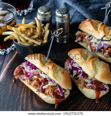 Three pulled pork slider buns on a wooden board ready for eating. Instagram crop.