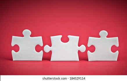 Three Puzzle Pieces On Red Background