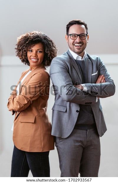Three quarter length business portrait of cheerful\
multi ethnic couple