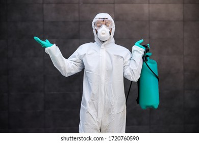 Three quarter length of confused man in protective sterile suit and mask holding disinfectant and hoping that he sterilized all surfaces. - Shutterstock ID 1720760590
