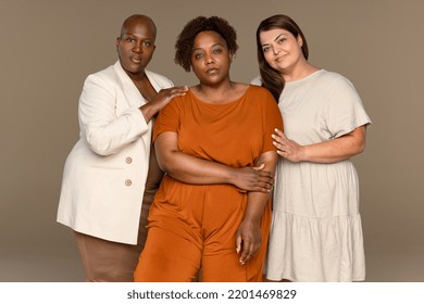 Three Quarter Length Portrait Of An African American Woman In Her 30's, A Black Woman In Her 50's, And A Middle Eastern Woman In Her 40's Confidently Looking At The Camera On A Neutral Background.