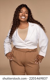 three quarter length portrait of confident and happy black woman in her 30s posing with hands on hips on a neutral background Stock Photo