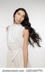 Three Quarter Length Portrait Of A Gorgeous Taiwanese Transgender Woman With Long Black Hair Posing On A White Background