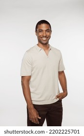 Three Quarter Length Shot Of Attractive Black Man In His 40s Posing Casually And Smiling On White Background