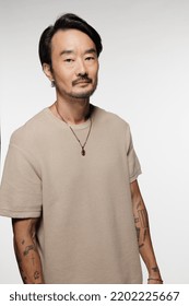 Three Quarter Length Shot Of Beautiful East Asian Man In His 40s Posing Confidently On White Background