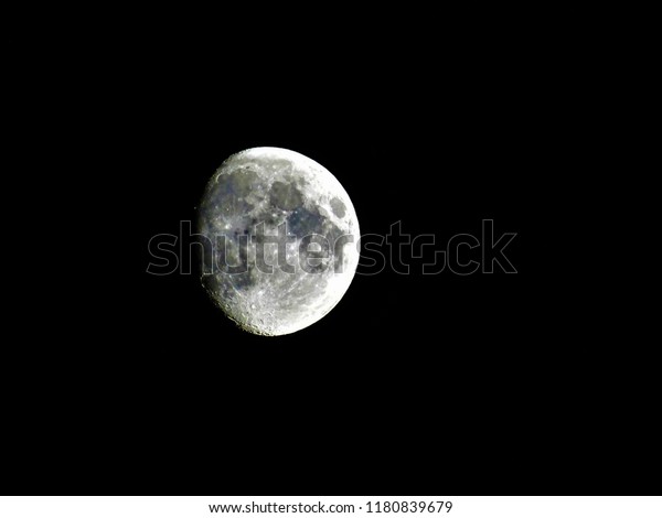 Three quarter moon\
shining on the night sky