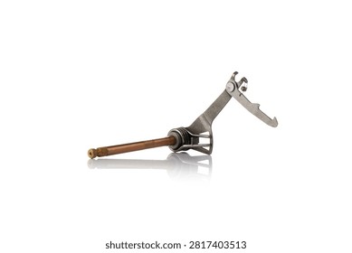 Three quarter perspective studio view of complete motorcycle gear shift shaft assembly featuring bronze plated splined rod, steel selector arm linkage, return torsion spring, and ratchet pawl, shot on reflective white background showcasing powertrain transmission repair hardware.
