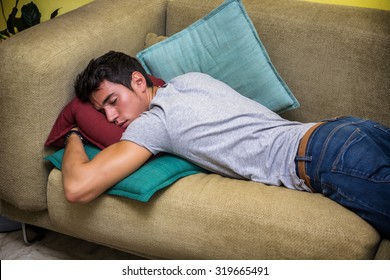 Three Quarter Shot of a Drunk Young Man Sleeping on the Couch in the Home Living Room.