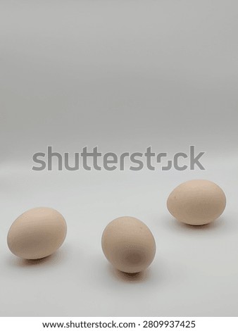 Three raw chicken eggs isolated on a white background