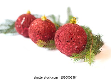 Three red baubles and pine branches isolated on white background. Christmas decoration concept