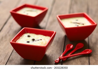 Three Red Bowls Of The Ecuadorian Dessert Called Morocho (coarsely Ground White Corn) Cooked With Milk, Sugar And Spices (cinnamon, Allspice) (Selective Focus, Focus On The Middle Of The First Bowl) 
