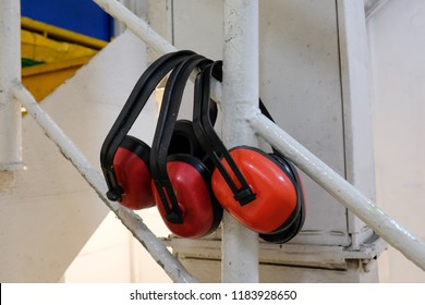 Three Red Ear Muffs In A Factory