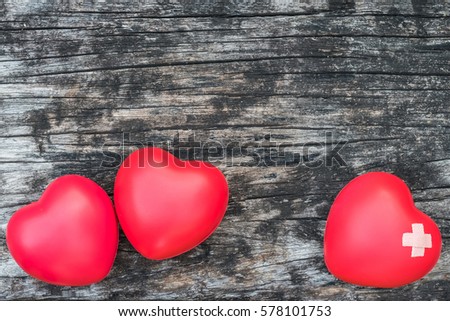  Three red hand exercise ball on grunge old aged wood background.