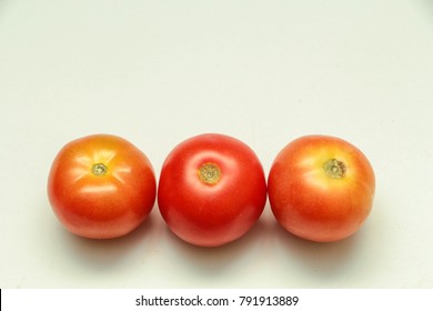 Three Red Tomatoes in white backround in top view