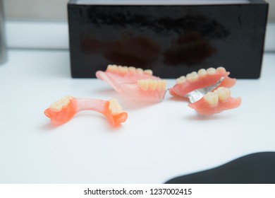 three removable metal partial dentures on a white table