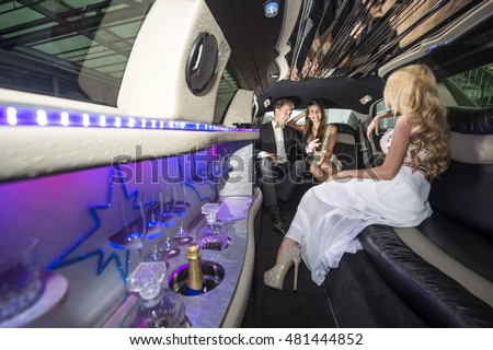 Three rich and famous people, celebrities, sitting in a luxurious limousine, chatting away, having a good time.