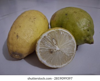 Three ripe lemons and a lime displaying fresh slices isolated on transparent background