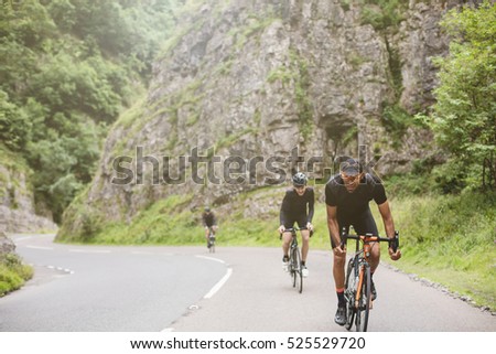 Three road cyclists attacking the climb in Cheddar Gorge
