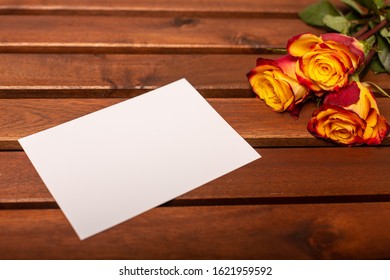 Three Roses With White Slip Of Paper On The Table. 