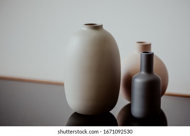 three round ceramic vases on the table
