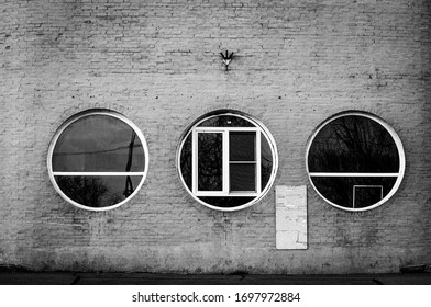three round Windows in the brick wall
