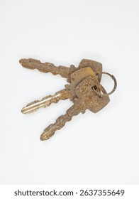 three rusty brown keys on a white background