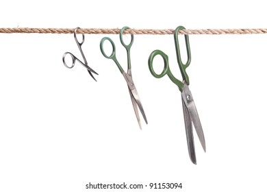 Three scissors hanging on a rope isolated on white background