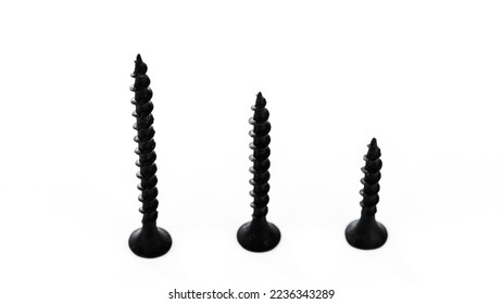 Three screws of different lengths. Selective focus. Isolated on white background.