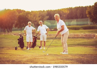 Three senior golfer on filed. Woman playing golf. - Powered by Shutterstock