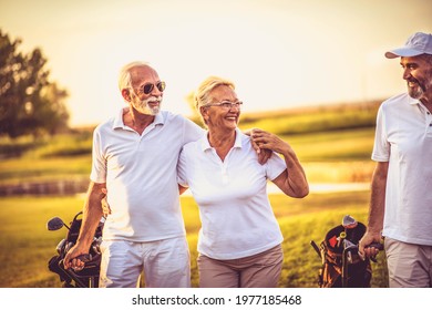 Three senior golfers walking and talking. - Powered by Shutterstock