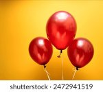 Three shiny red balloons set against a vibrant yellow background, creating a cheerful and festive atmosphere. Perfect for celebrations and events, adding a pop of color and joy to any occasion.