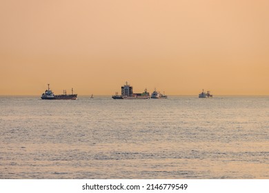 Three ships of various sizes on hazy horizon at sunset - Powered by Shutterstock