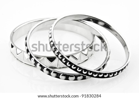 Three silver bracelet placed on white