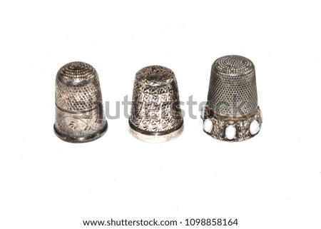 Three Silver Thimbles on White Background